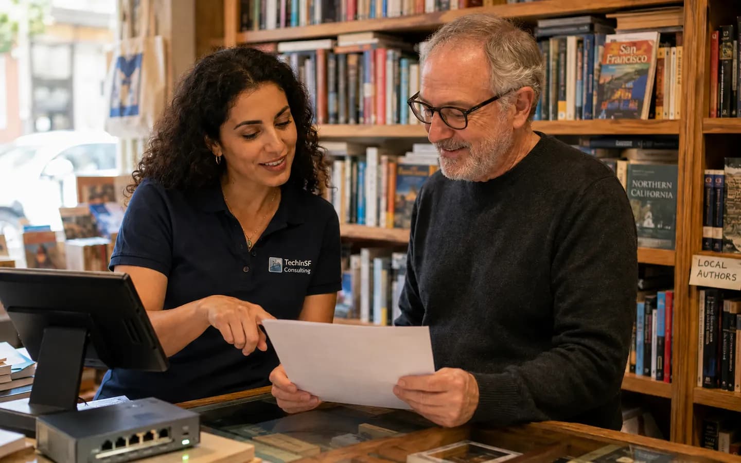 A TechInSF consultant going over a service plan with the owner of a San Francisco bookshop